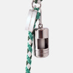A silver dog poop bag holder attached to a green and white braided cord leash, featuring a silver metal tag engraved with 'JAMIE DOGWEAR'.